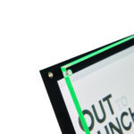 Deflecto Wall-Mounted Sign Holder – Frame Style – angled close-up showing the stand-off wall fixing