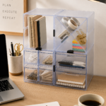 Deflecto Stackable Cube Clear Organiser stacked on a desk storing stationery and tape